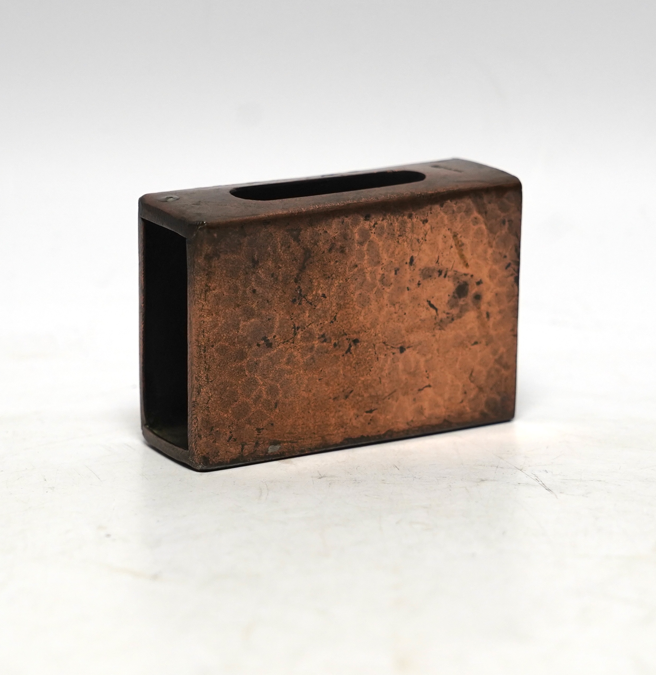 A Newlyn copper matchbox cover, decorated with a fish, 7.5cm wide